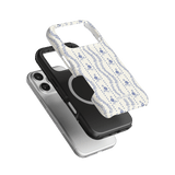 Riviera iPhone case featuring a floral design in blue and white, layered over black and clear cases.