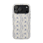 Riviera iPhone case featuring a floral design with blue flowers on a cream background, showing the back and camera cutout.