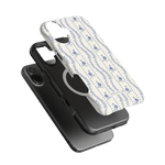 Riviera iPhone case featuring a floral pattern in blue on a white background, layered over a black phone case.