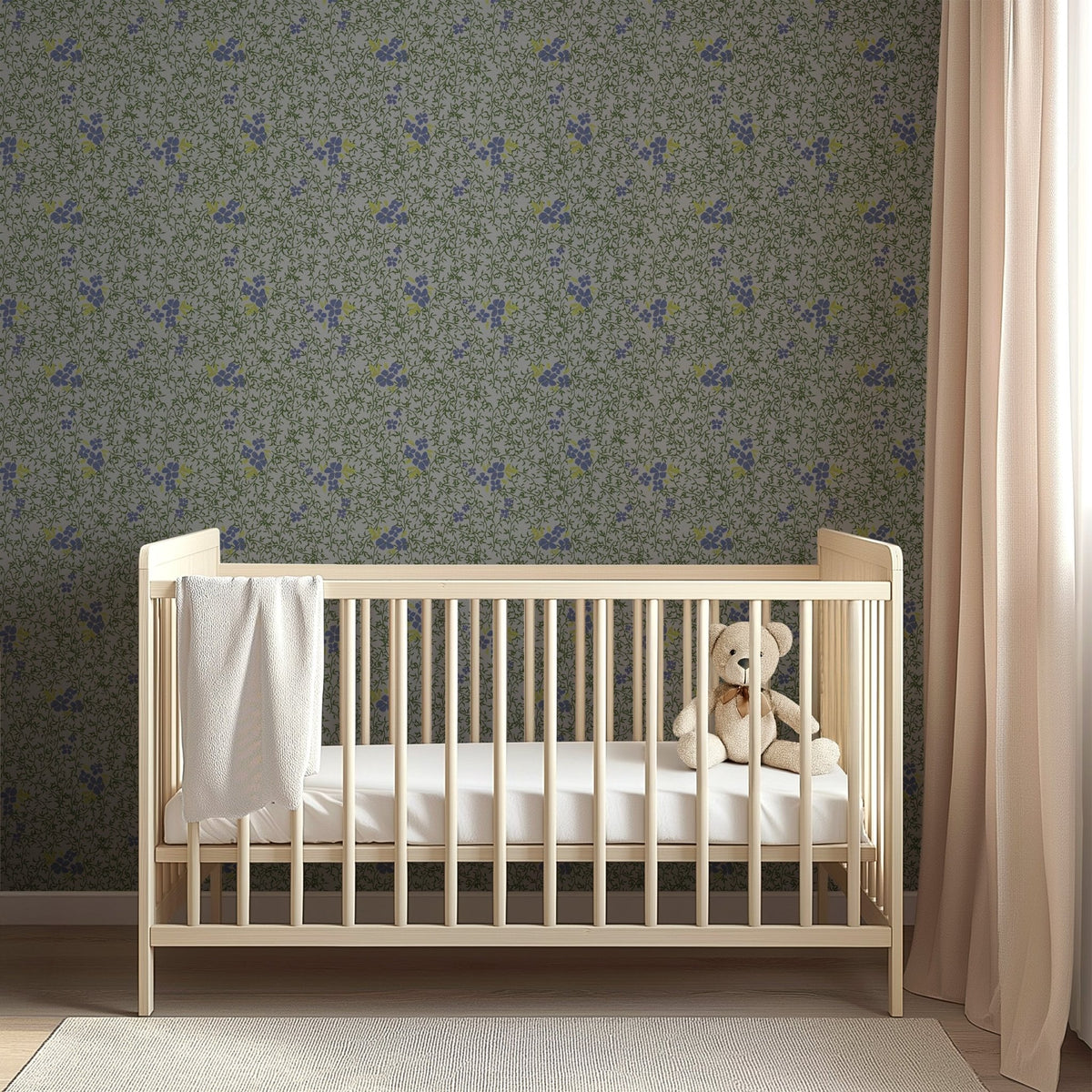 Light wood crib against Roxanne floral wallpaper by Pen and Pillar featuring small purple and yellow flowers on green vines.