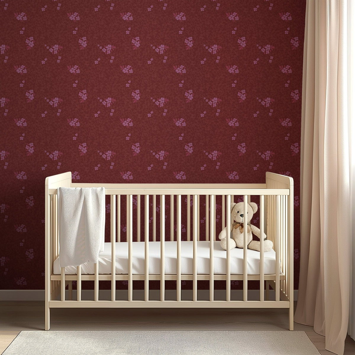 Burgundy Roxanne wallpaper with pink floral patterns behind a light wood crib with a teddy bear and white blanket.