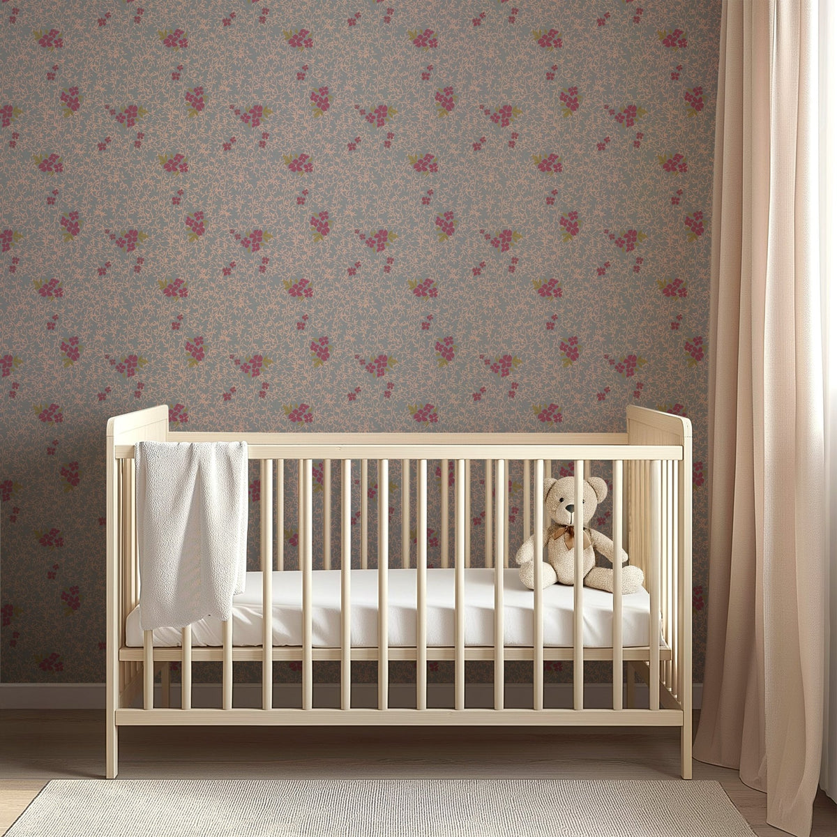 Light wood crib against Roxanne by Pen and Pillar wallpaper featuring a pink floral pattern on a blue-grey background.