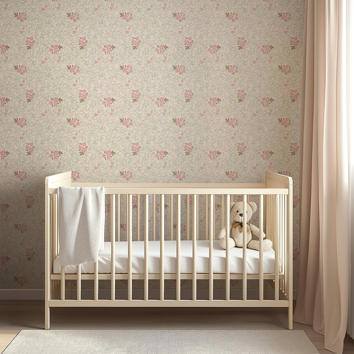 Roxanne Wallpaper by Pen and Pillar featuring pink floral patterns on a wall behind a light wood crib.