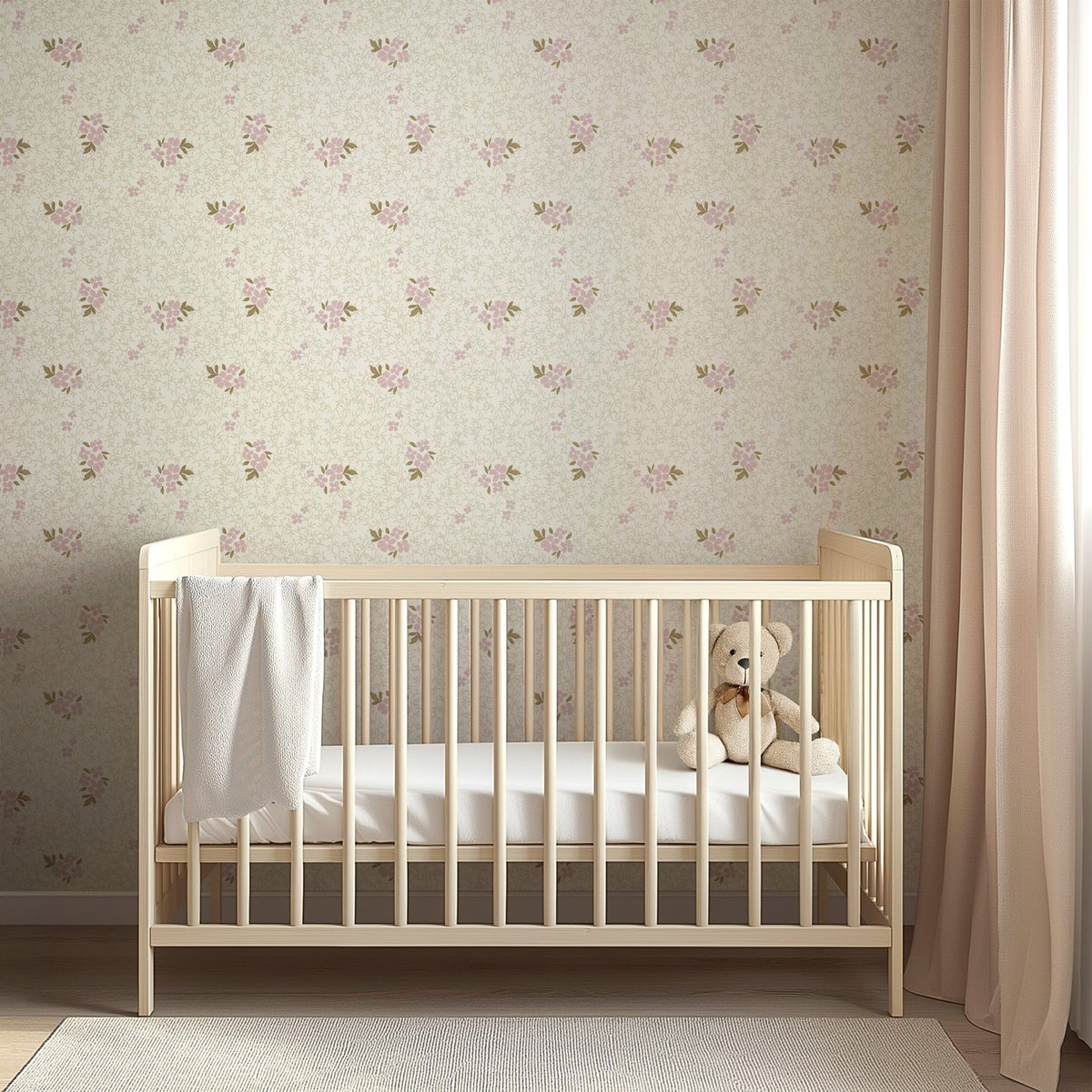 Roxanne Wallpaper by Pen and Pillar featuring a pink floral pattern on a cream wall behind a light wood crib.