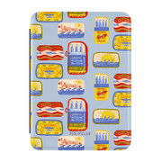 Light blue Kindle case with a pattern of colorful sardine and mackerel tins. PEN+PILLAR is printed at the bottom.