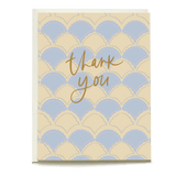Scalloped pattern thank you card in pastel blue and cream with gold cursive text saying "thank you.