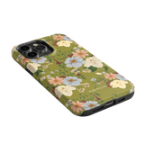 Scarlett iPhone case featuring a floral design with colorful flowers on a green background, angled view.