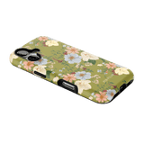 Scarlett iPhone case featuring a floral design with pastel flowers on a green background, angled view.