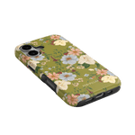 Scarlett iPhone case featuring a floral design with yellow, pink, and white flowers on a green background.