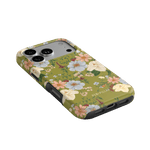 Scarlett iPhone case featuring a floral design with pink and white flowers on a green background.