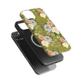 Scarlett iPhone case featuring a floral design with green background and various colored flowers, shown on a black phone.