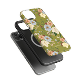 Scarlett iPhone case featuring a floral design with green background and colorful flowers, shown on a black phone.