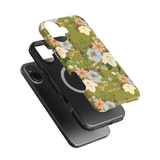 Scarlett iPhone case featuring a floral design with colorful flowers on a green background, layered over a black phone case.