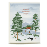 Snow Day Holiday Card featuring snowy landscape, pine trees, children playing, and a black dog with red text above.