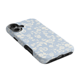Spritz iPhone case featuring a light blue floral pattern with white flowers and black edges, angled view.