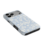 Spritz iPhone case featuring a light blue floral pattern with black edges, angled to show camera and ports.