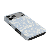 Spritz iPhone case featuring a light blue floral pattern with black edges, angled to show camera and ports.