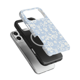 Spritz iPhone case featuring a light blue floral design, layered over a black and silver phone case.