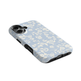 Spritz iPhone case featuring a light blue floral pattern with white accents, angled to show the camera cutout.