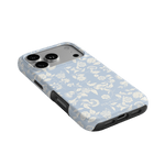 Spritz iPhone case featuring a light blue floral design with black edges, angled view showing camera cutout.