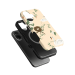 Swan Hollow iPhone case featuring a floral design with swans on a light background, layered over a black phone case.