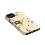 Swan Hollow iPhone case featuring swans, a nest, and floral designs on a peach background.