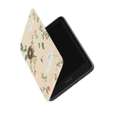 Swan Hollow Kindle case with a beige background, featuring swans and floral designs, partially open to reveal the screen.