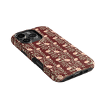 Thicket iPhone case featuring a floral pattern in shades of pink and burgundy on a black background.