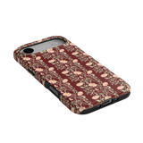 Thicket iPhone case featuring a maroon background with floral patterns and a textured finish.