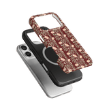 Thicket iPhone case featuring a floral design in burgundy, stacked over a black and a clear case.