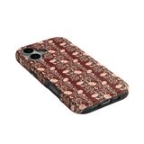 Thicket iPhone case featuring a floral pattern in shades of pink and cream on a dark maroon background.