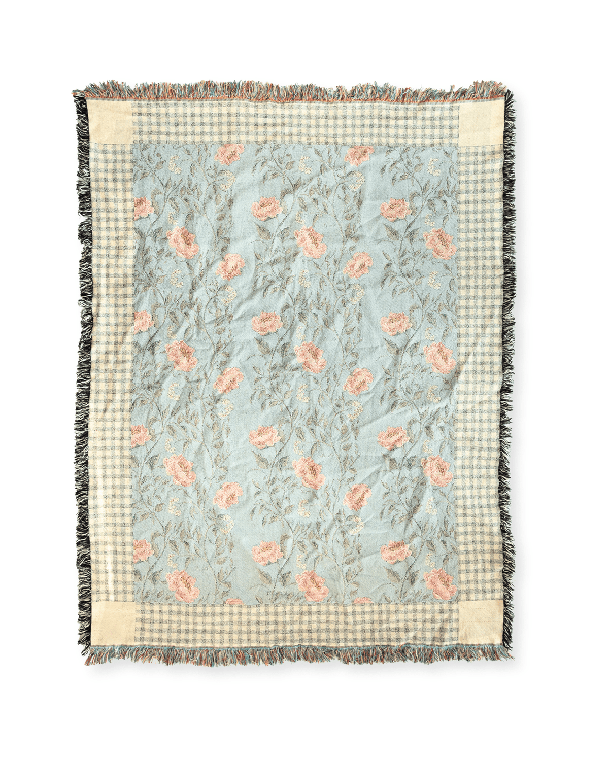 Thicket woven blanket featuring a floral pattern in soft pink and green on a light blue background with fringed edges.