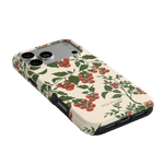 Tomato vines iPhone case featuring a cream background with red tomatoes and green leaves, angled to show side ports.