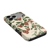 Tomato vines iPhone case featuring a cream background with red tomatoes and green leaves, angled to show side ports.