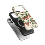 Tomato vines iPhone case featuring a floral design with red tomatoes on a cream background, layered over two other cases.