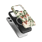 Tomato vines iPhone case featuring a floral design with red tomatoes on a cream background, layered over two other cases.