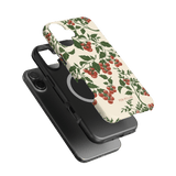 Tomato vines iPhone case featuring a floral design with red tomatoes on a cream background, shown with a black phone.