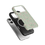 Vine+Bloom iPhone case featuring a green floral design with pink accents, layered over black and clear cases.