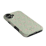 Vine+Bloom iPhone case featuring a floral pattern with pink flowers on a light green background.