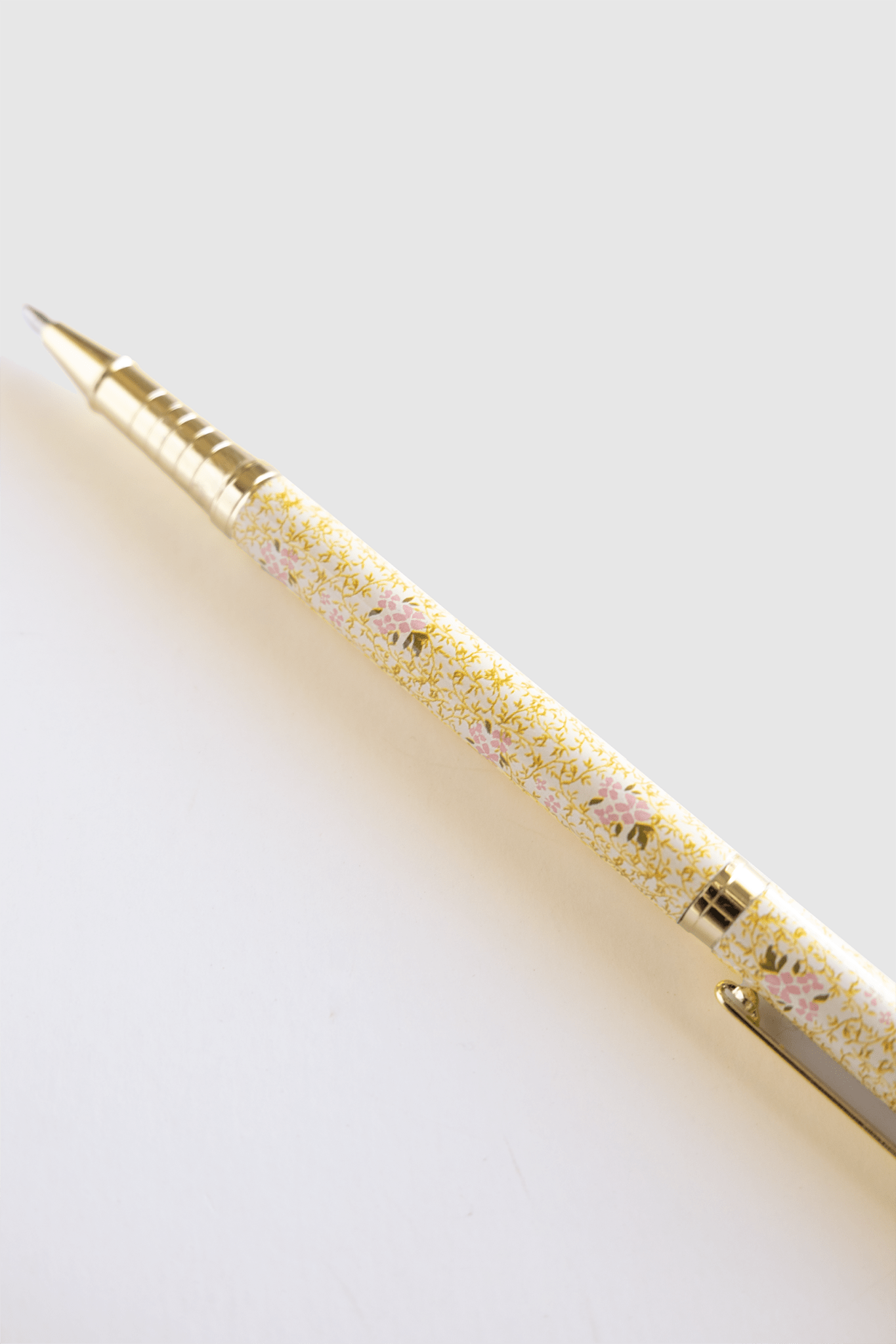 Vine+Bloom metal pen with a floral yellow and pink design, featuring a gold clip and tip.