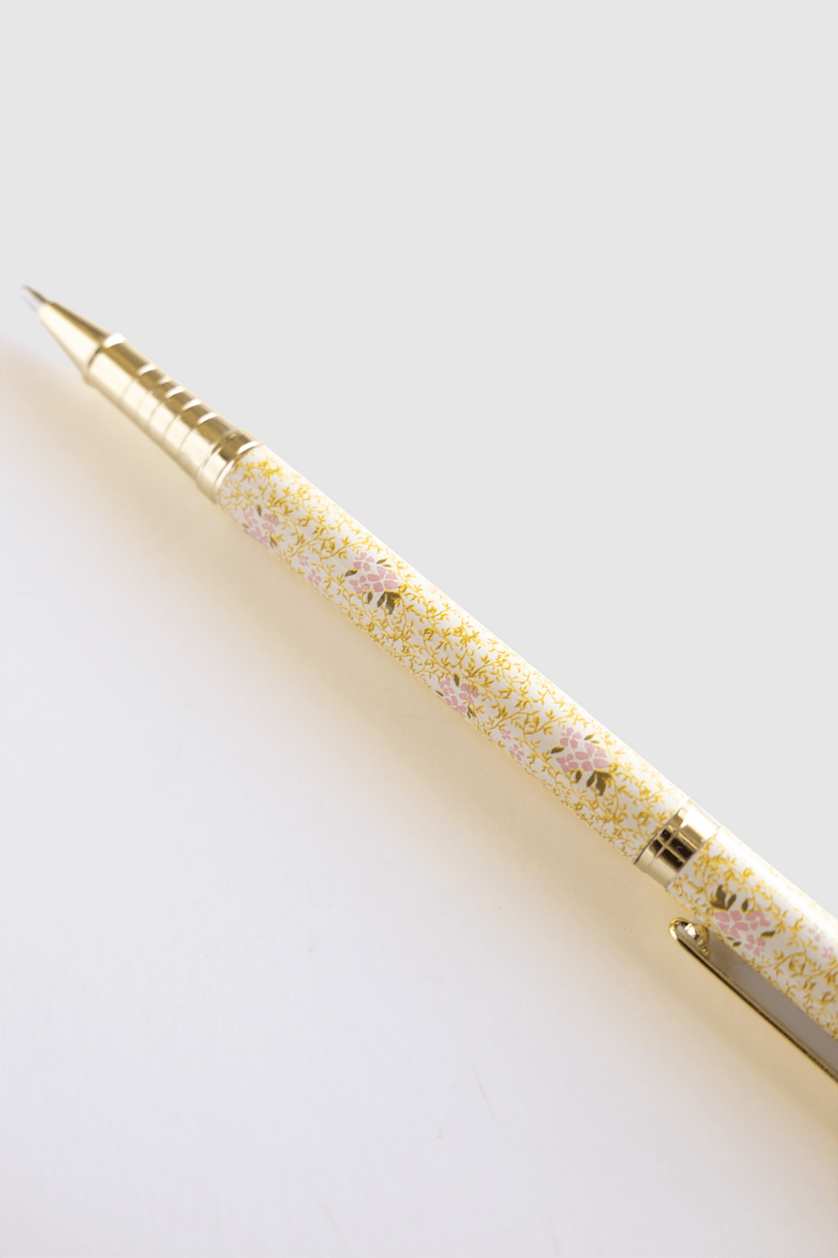 Vine+Bloom metal pen with a floral yellow and pink design, featuring a gold clip and tip.