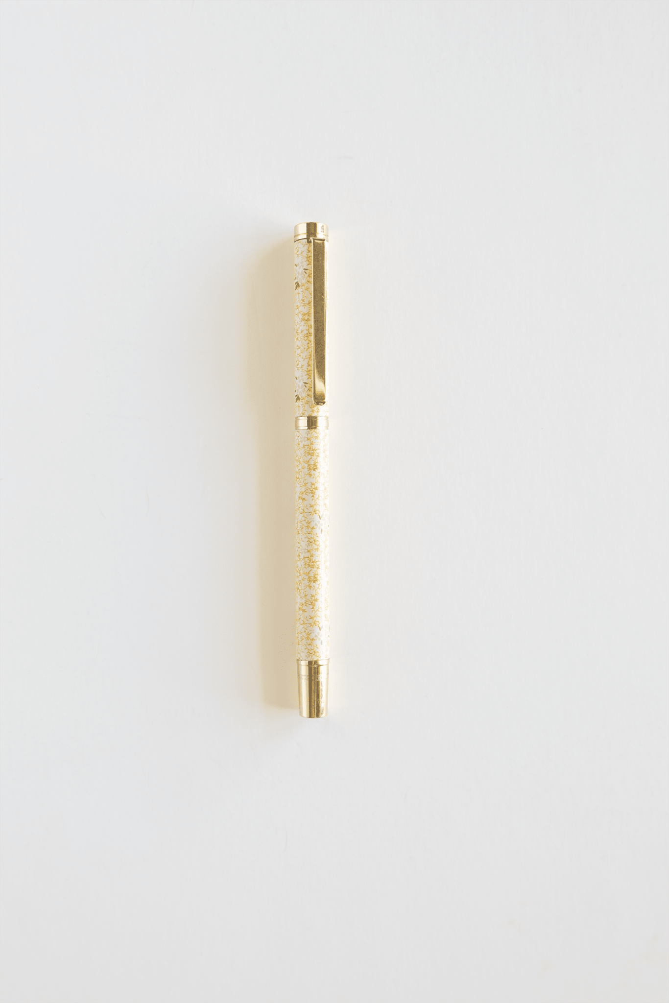 Vine+Bloom metal pen with a gold finish and a glittery yellow barrel on a white background.