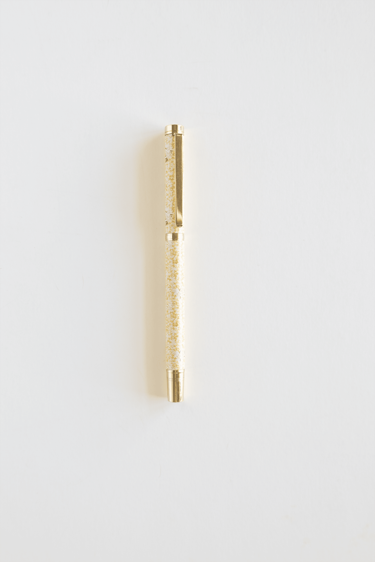 Vine+Bloom metal pen with a gold finish and a glittery yellow barrel on a white background.