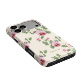 Viola iPhone case featuring a floral design with pink and red flowers on a cream background, angled view.