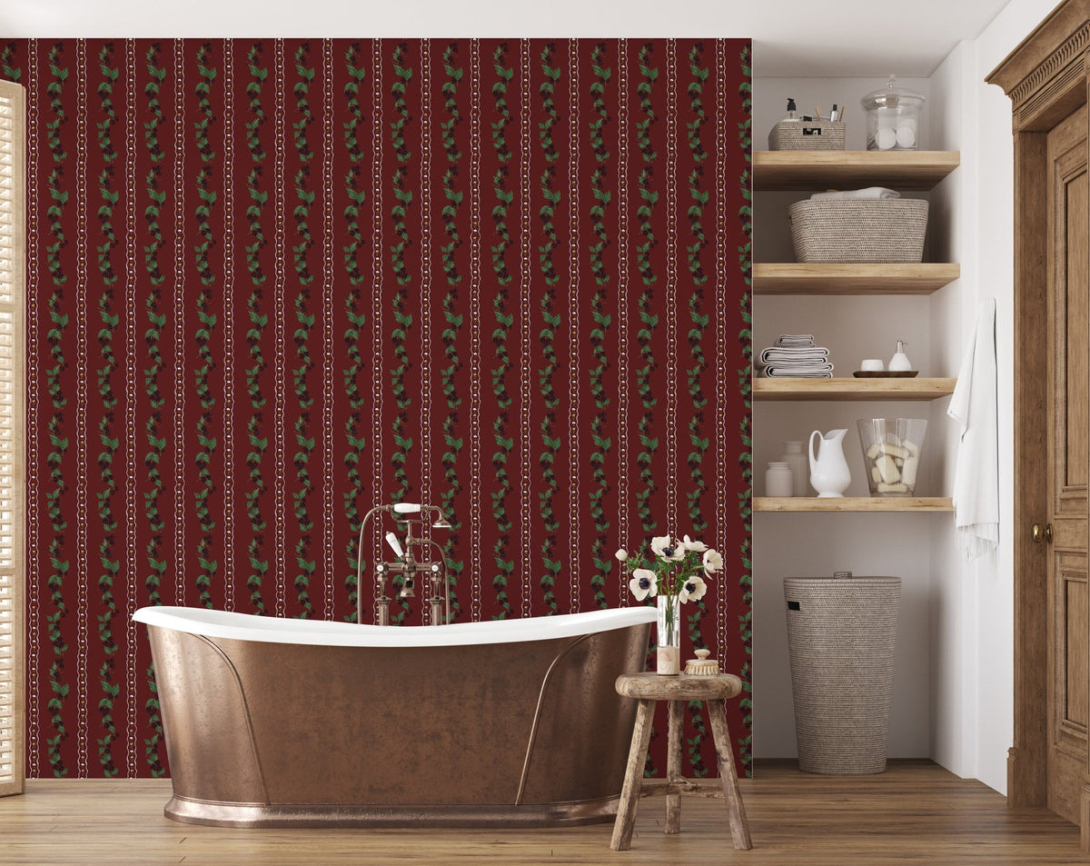 Red wallpaper with vertical green leaf and white chain patterns behind a metal bathtub in a bathroom.