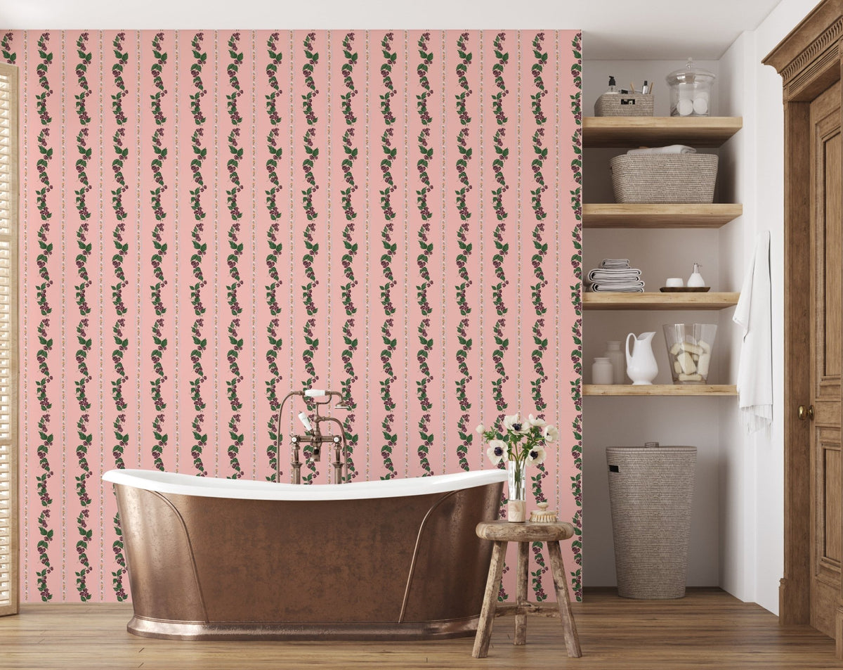 Pink wallpaper with vertical floral vine patterns behind a metal bathtub in a bathroom with wood floors and shelving.