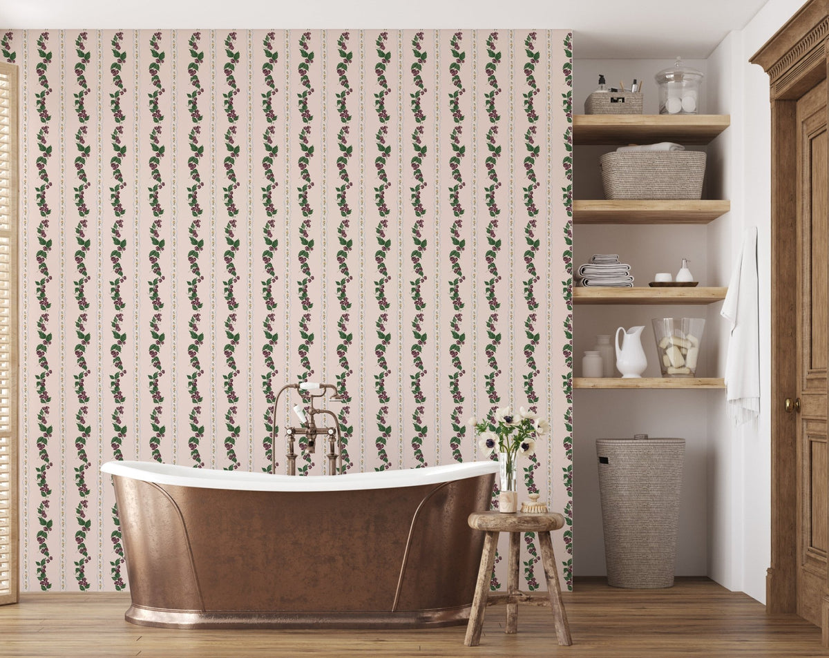 Pink Wrenley wallpaper with vertical floral and leaf vine stripes behind a copper bathtub in a bathroom.