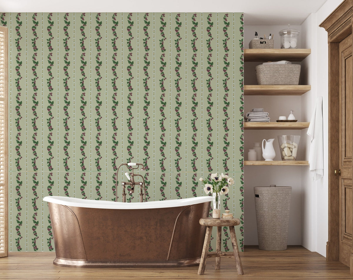 Green Wrenley wallpaper with floral vine stripes behind a copper bathtub and wooden shelves.